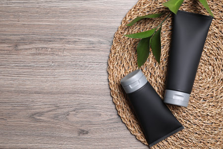 Men's cosmetic products in black tubes on wooden table, top view. Space for textの写真素材