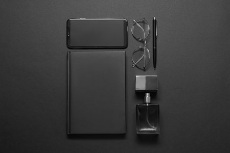 Flat lay composition with male accessories and smartphone on black backgroundの写真素材