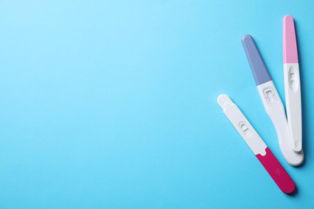 Different pregnancy tests on light blue background, flat lay. Space for textの写真素材