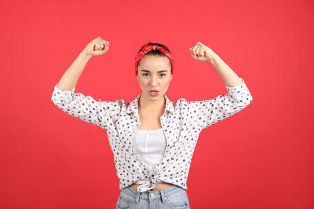 Strong woman as symbol of girl power on red background. 8 March conceptの写真素材