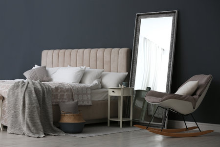 Elegant mirror near bed in stylish room interiorの写真素材