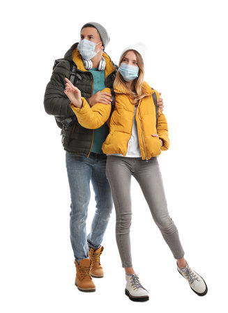 Couple in face masks and warm clothes on white background. winter travelの写真素材