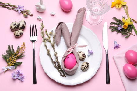 Festive Easter table setting with eggs on pink background, flat layの写真素材