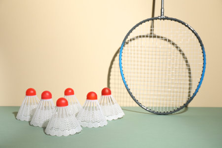 Shuttlecocks and racquet against beige background. badminton equipmentの写真素材