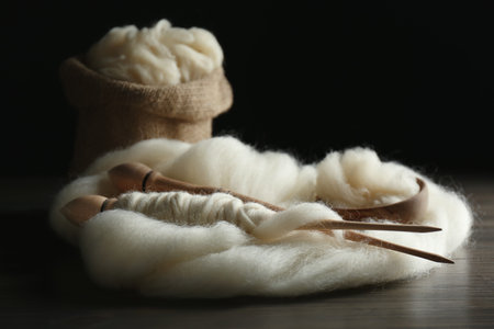 Soft white wool with spindles on wooden tableの写真素材
