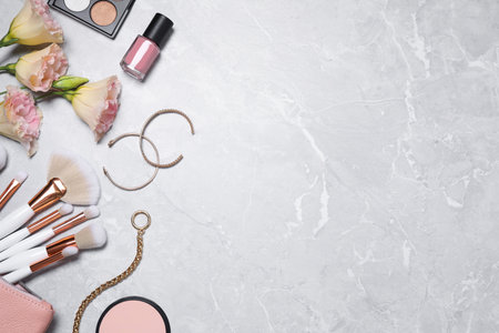 Flat lay composition with makeup products and accessories on light gray marble background. Space for textの写真素材