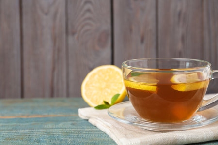 Tasty lemon tea on light blue wooden table, closeup. Space for textの写真素材