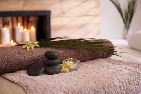 Beautiful spa accessories on massage table in roomの写真素材