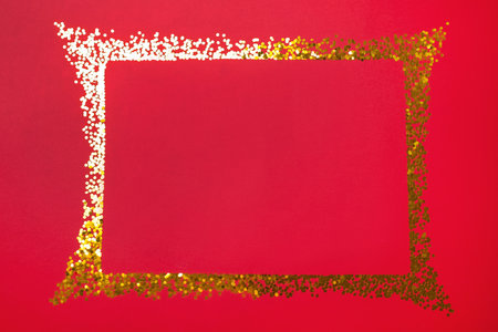 Frame of shiny gold glitter on red background, flat lay. Space for textの写真素材