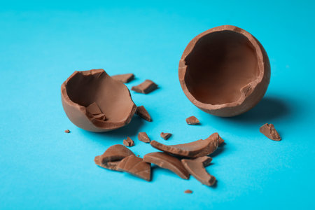 Broken chocolate egg on light blue backgroundの写真素材