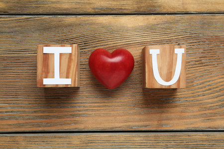 Phrase I Love You made of cubes with letters and heart on wooden table, flat layの写真素材