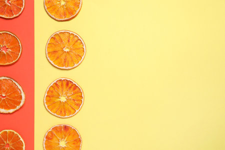 Delicious dried orange slices on color background, flat lay. Space for textの写真素材