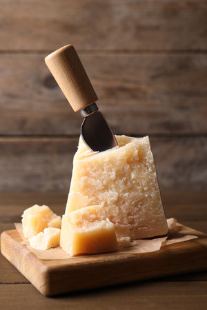 Delicious parmesan cheese with knife on wooden tableの写真素材