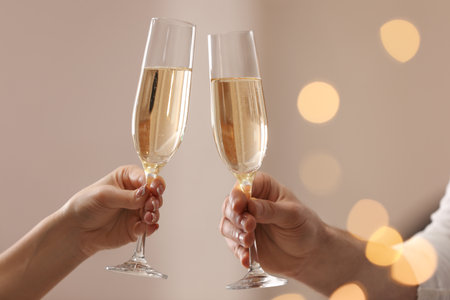 People clinking glasses of champagne against blurred background, closeup. bokeh effectの写真素材