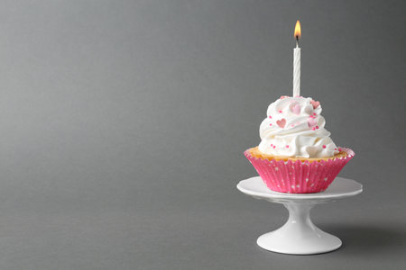 Delicious cupcake with candle on gray background. Space for textの写真素材