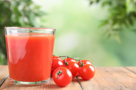 Delicious tomato juice and vegetables on wooden table. Space for textの写真素材