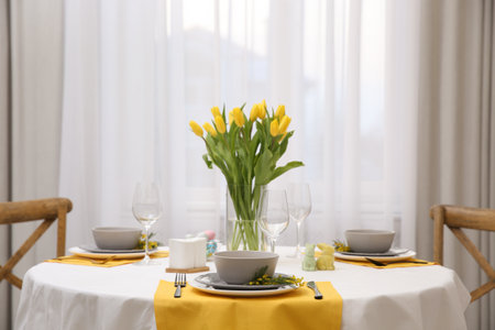 Beautiful Easter table setting with floral decor indoorsの写真素材