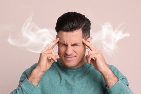 Stressed and upset young man on light backgroundの写真素材