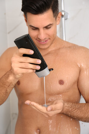 Man applying gel in shower at homeの写真素材
