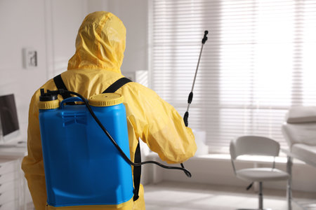 Man in protective suit sanitizing doctor's office. medical disinfectionの写真素材