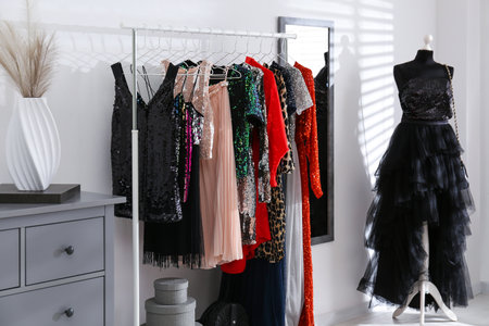 Rack with collection of festive beautiful clothes in stylish room interiorの写真素材