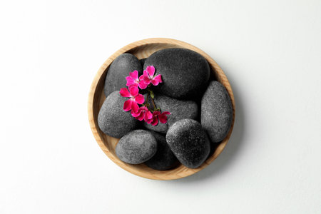 Spa stones and beautiful flowers on white table, top viewの写真素材