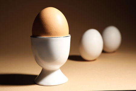 Chicken egg in cup on beige background. Space for textの写真素材