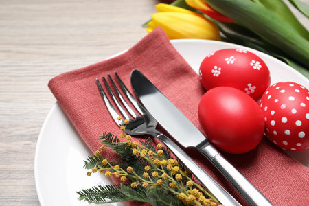 Festive Easter table setting with eggs on wooden background, closeup