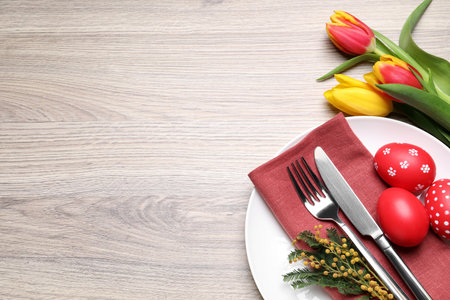 Festive Easter table setting with eggs on wooden background. Space for text