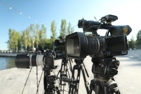 Modern professional video cameras outdoors on sunny day