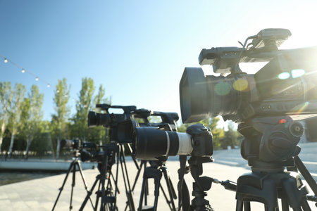 Modern professional video cameras outdoors on sunny dayの写真素材