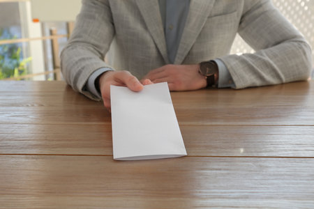 Employee with resignation letter at table in office, closeupの写真素材