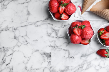 Yummy strawberry ice cream served on white marble table, flat lay. Space for textの写真素材