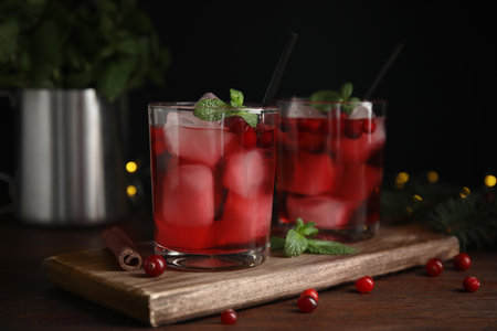 Tasty refreshing cranberry cocktail with mint on wooden tableの写真素材