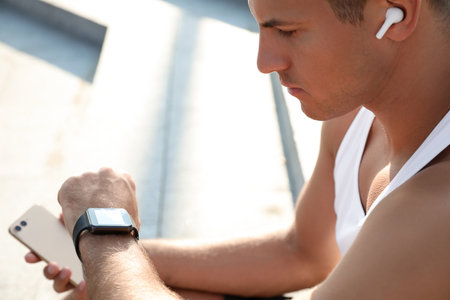 Man checking fitness tracker after training outdoors, closeupの写真素材