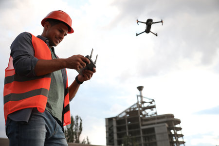 Builder operating drone with remote control at construction site. aerial photography