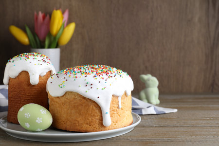 Easter cakes and color egg on wooden table, space for text