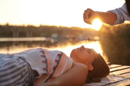 Woman at crystal healing session near river outdoorsの写真素材