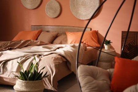 Bed with orange and brown lines in stylish room interiorの写真素材