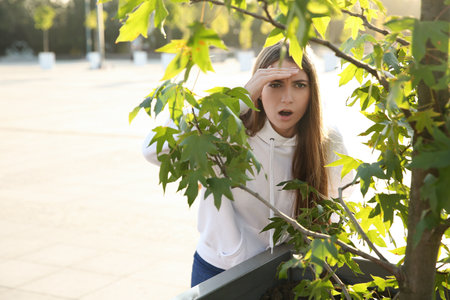 Jealous woman spying on ex boyfriend outdoorsの写真素材