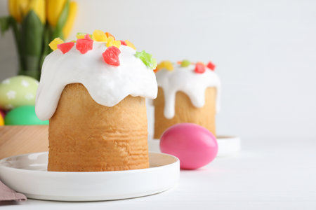 Easter cakes and color eggs on white table, space for text