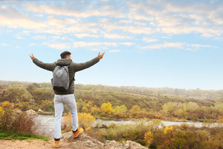 Traveler with backpack enjoying beautiful view on sunny day. autumn vacationの写真素材