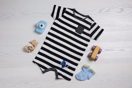 Flat lay composition with baby clothes and toys on white wooden tableの写真素材
