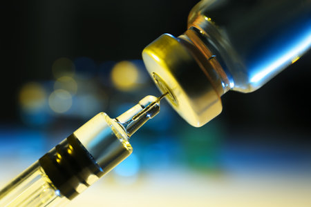 Filling syringe with vaccine from vial on blurred background, closeupの写真素材