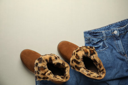 Stylish boots and jeans on grey background, flat lay. Space for textの写真素材