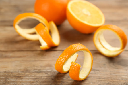Fresh spiral orange peels on wooden tableの写真素材