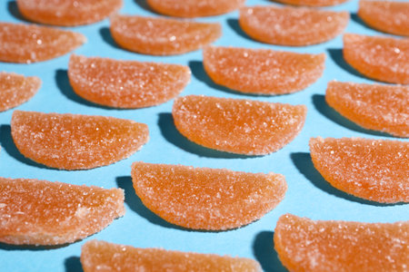 Delicious orange marmalade candies on light blue backgroundの写真素材