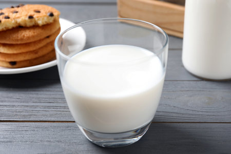 Glass of delicious milk on grey wooden tableの写真素材