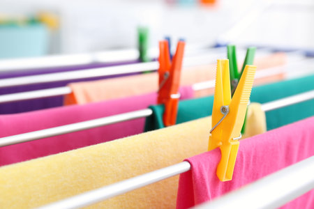 Clean laundry hanging on drying rack indoors, closeupの写真素材