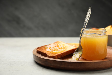 Delicious toast with orange marmalade on light grey table. Space for textの写真素材